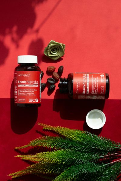 pexels-photo-29183559-29183559 Colorful flat lay of beauty supplements and decor on vibrant red background.